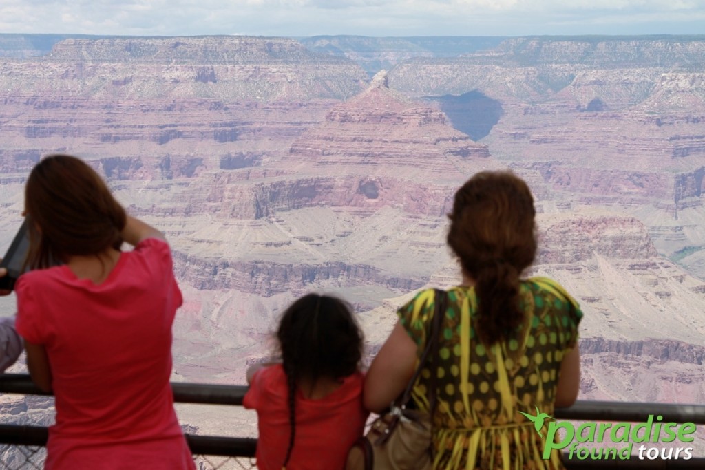 Tourists stand in awe as they view the rock formations at Mather Point Grand Canyon South Rim.